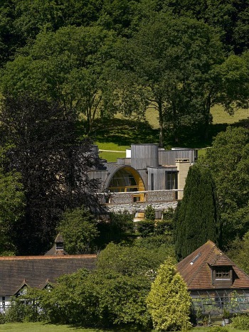 The ruin wall incorporated in the new house appears in foreground. A medieval or fairy-tale effect